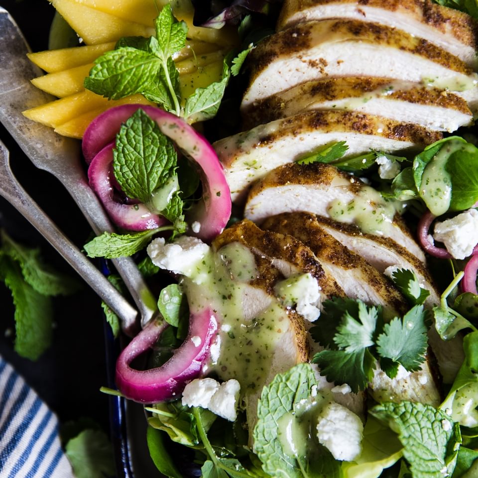 Grilled chicken salad with curry and mangos and pickled onions and avocado and mint