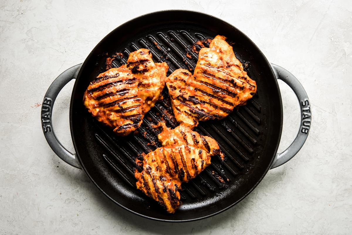 harissa marinaded chicken cooking in a grill pan