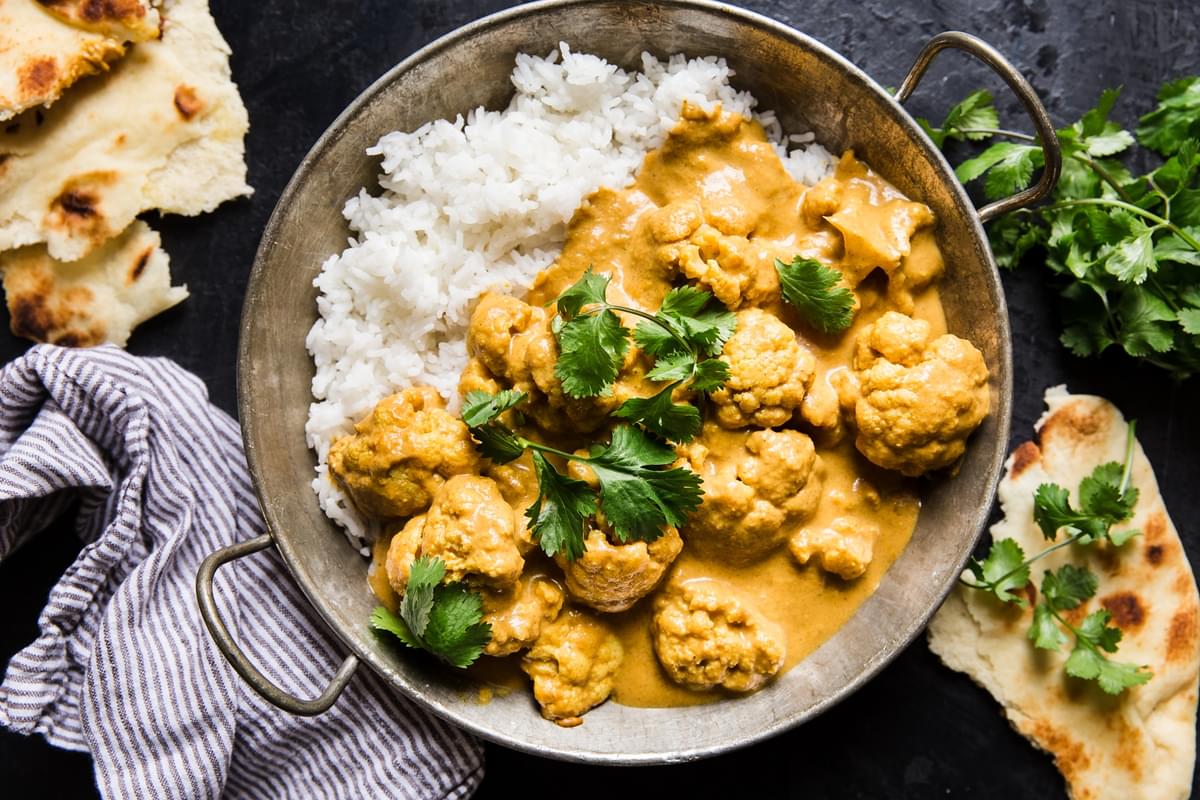 Indian style cauliflower curry on rice served with torn naan