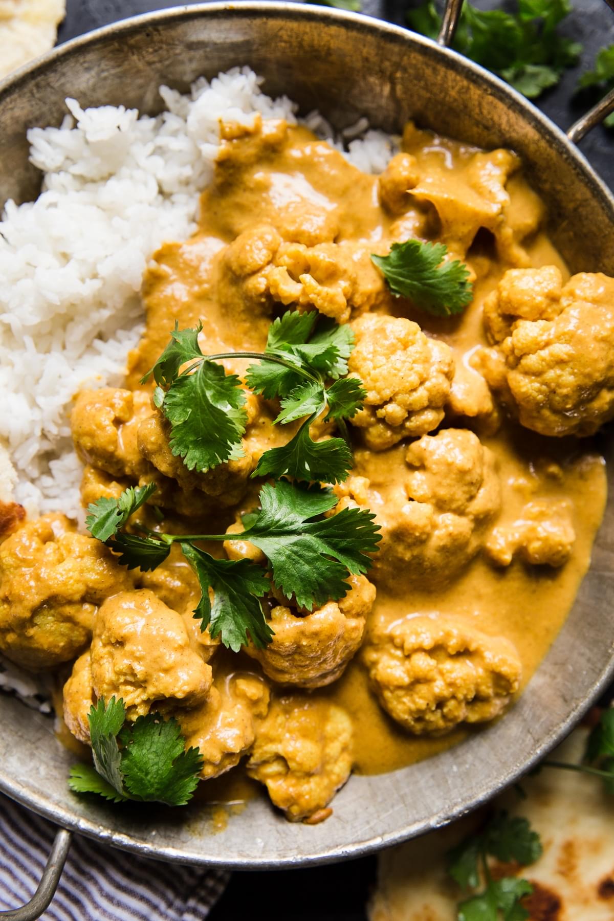 Indian style cauliflower curry on white rice in a large serving bowl