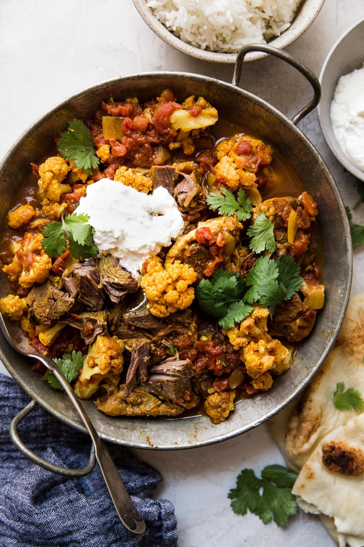 Indian Style Lamb Curry With Cauliflower with cilantro, tomatoes and yogurt.