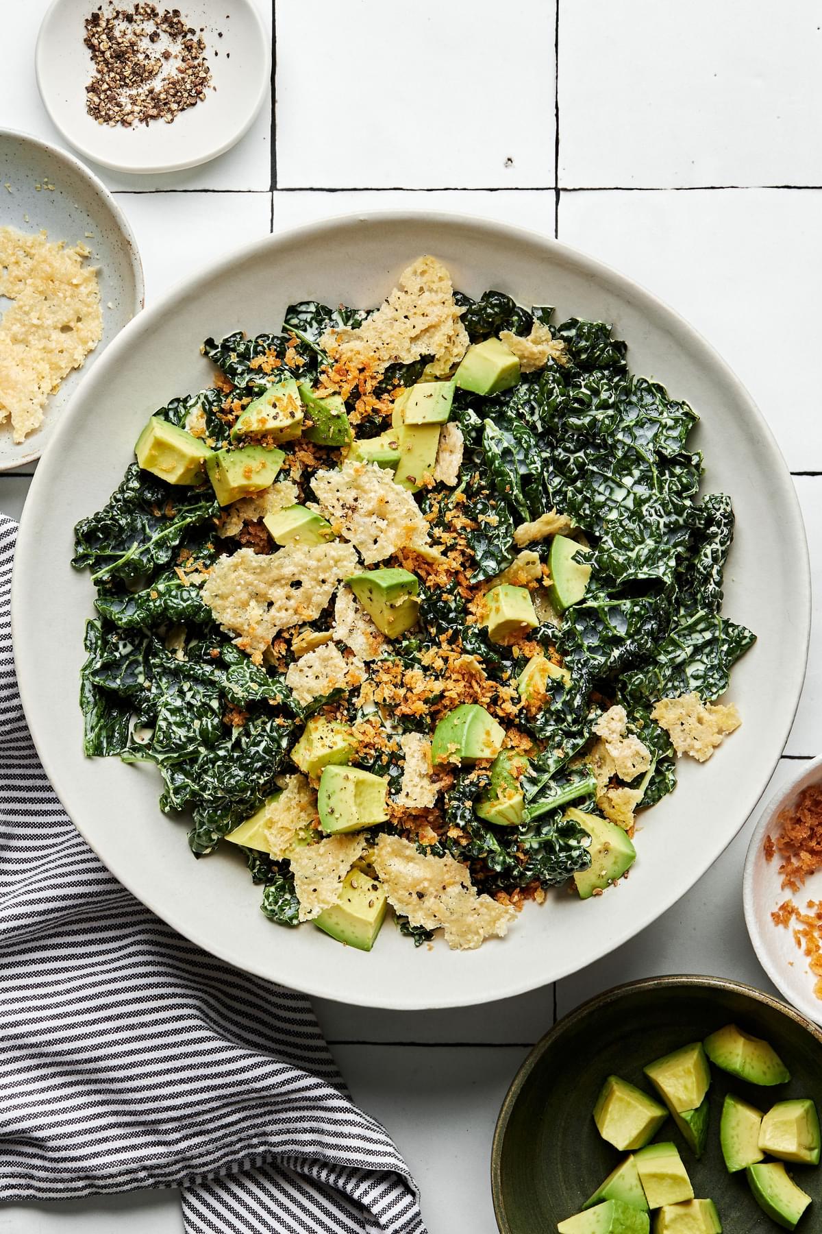 kale caesar salad made with homemade caesar dressing, avocado, toasted panko breadcrumbs and parmesan in a bowl with a fork