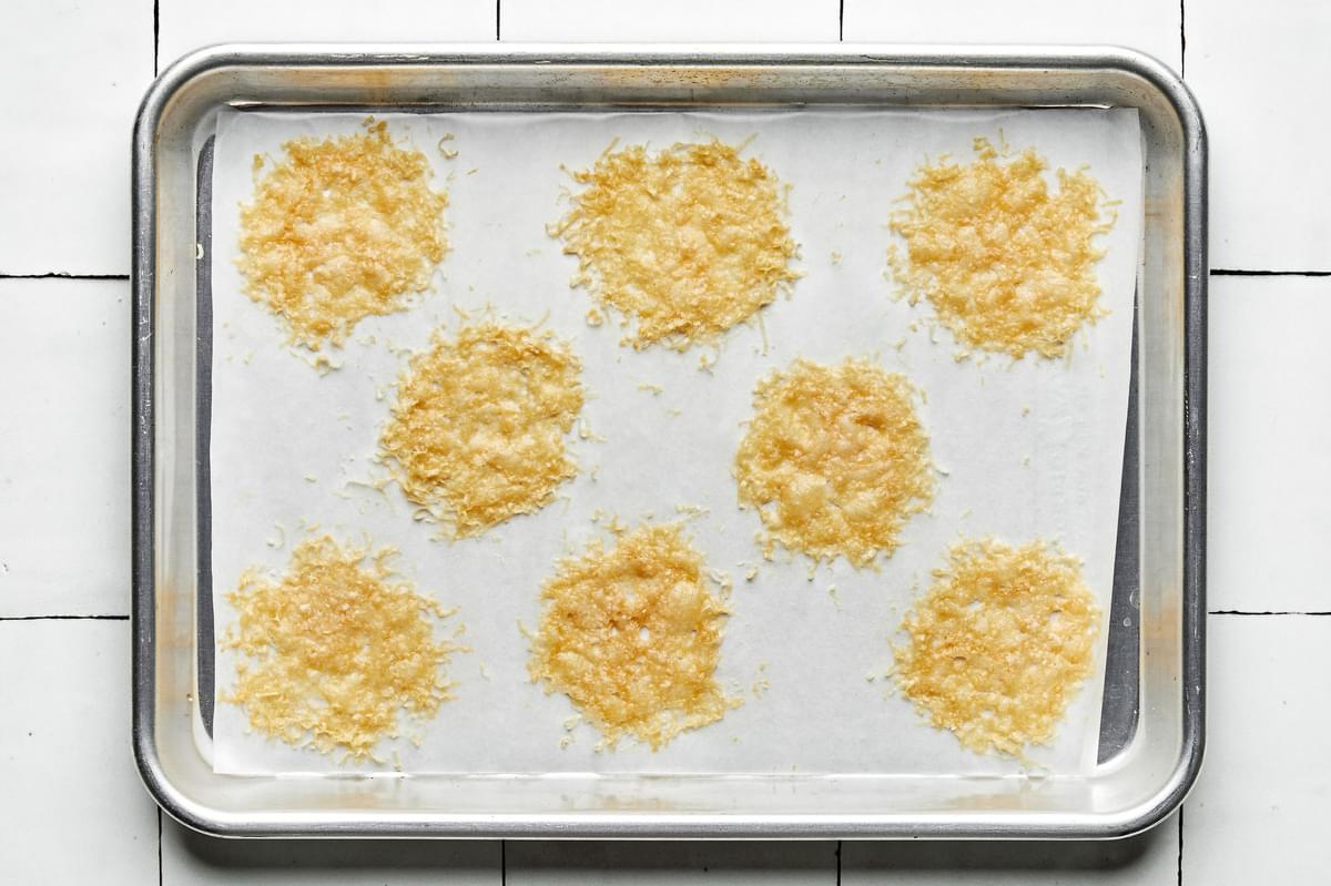 Baked parmesan crisps on a parchment lined baking sheet