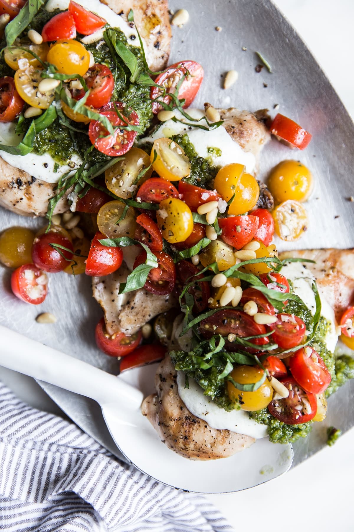 Pesto chicken bruschetta with cherry tomatoes, basil and pine nuts on a plate