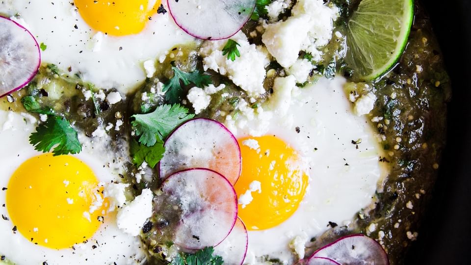 3 eggs baked in salsa verde with radishes and lime and cilantro