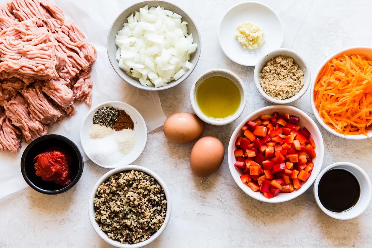 Ingredients laid out for Turkey Quinoa Meatloaf, onion, bell peppers, 2 eggs, spices, tomato paste, carrots brown sugar