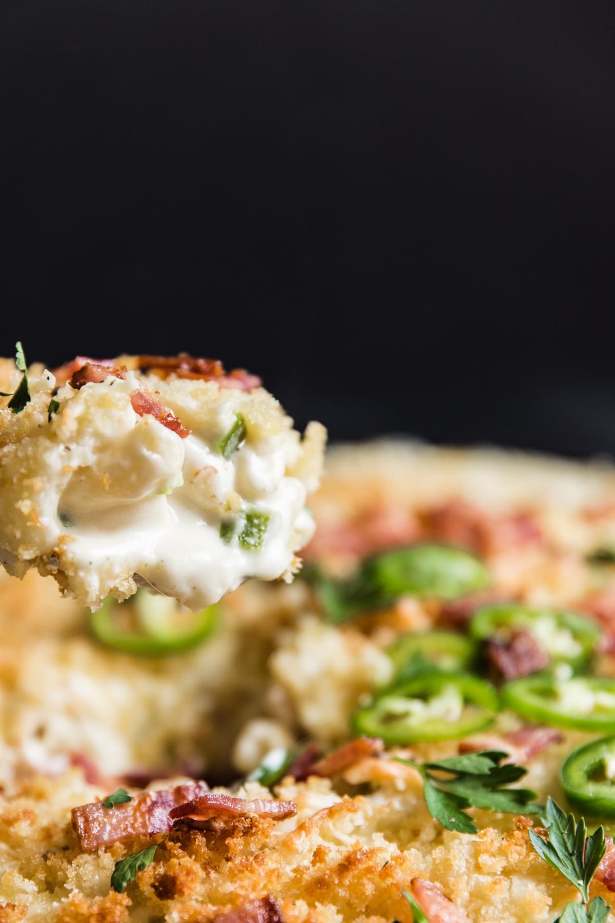a scoop on jalapeno mac and cheese on a spoon with panko bread crumbs