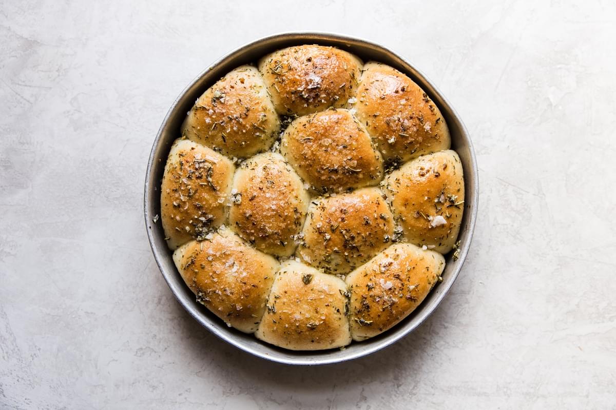 golden brown rhodes dinner rolls fresh out of the oven with garlic, herb butter.