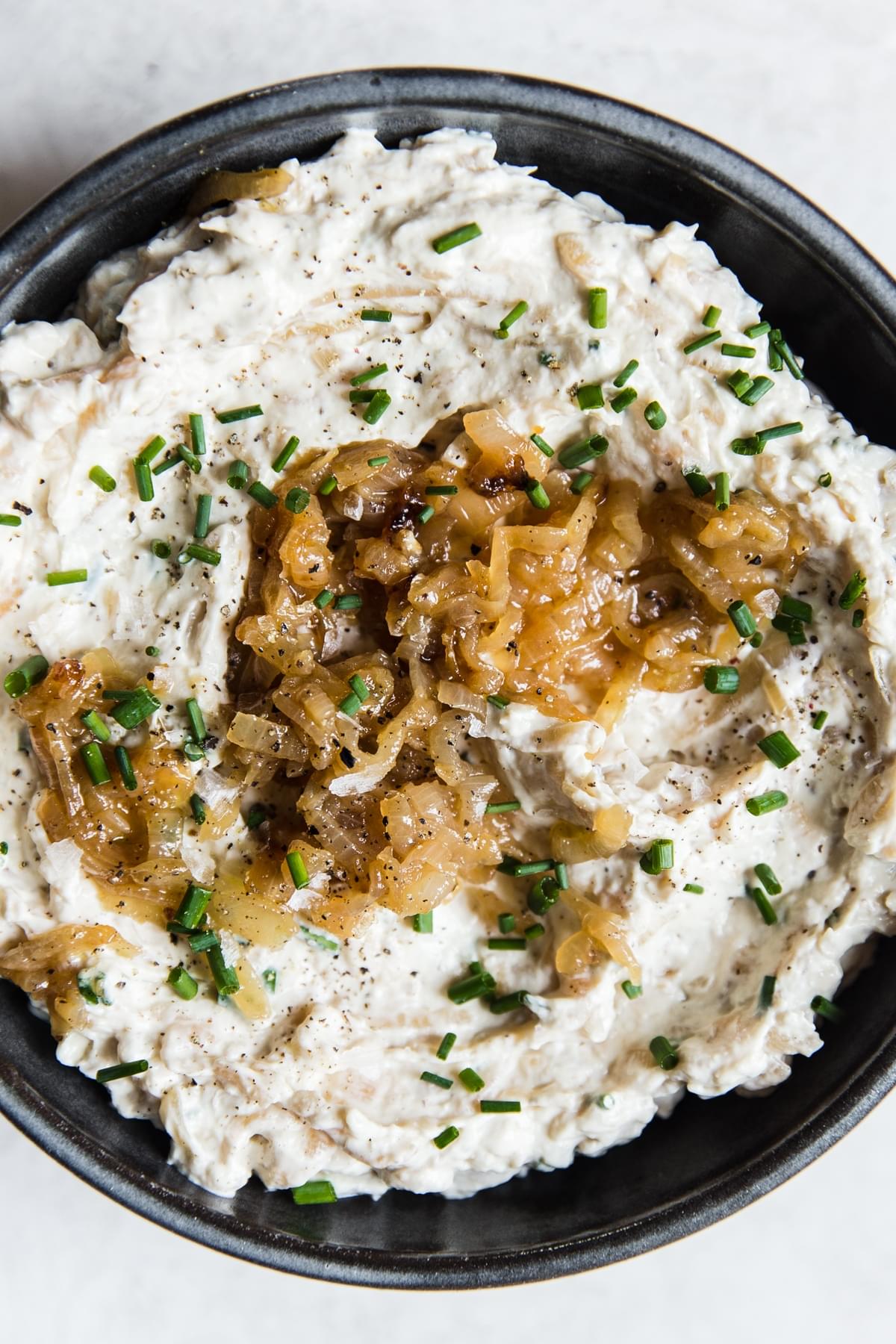 caramelized onion dip in a bowl with chives