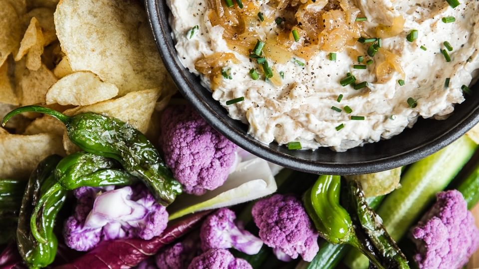 Caramelized onion dip  in a bowl with vegetables