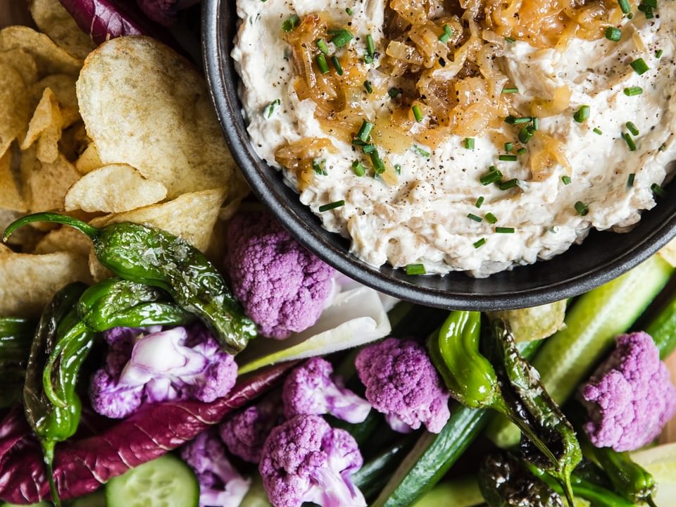 Caramelized onion dip  in a bowl with vegetables