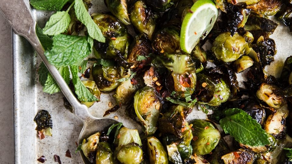 crispy Brussels sprouts with sweet fish sauce, mint and cilantro on a baking sheet