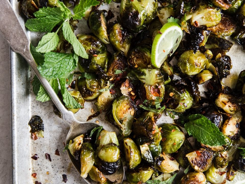 crispy brussels sprouts with with sauce on a baking sheet