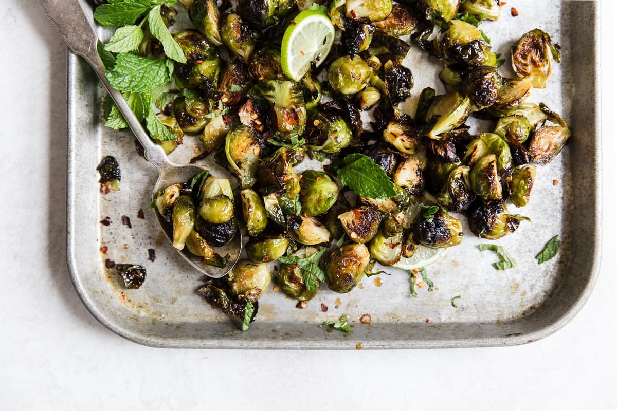 Crispy Brussels Sprouts With sweet Fish Sauce, and mint on a baking sheet