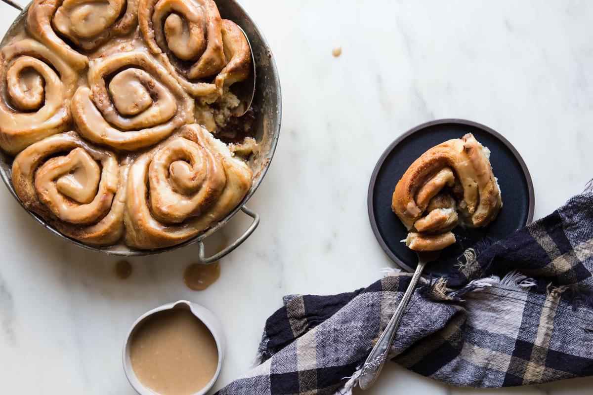 a pan of homemade cinnamon rolls with maple frosting