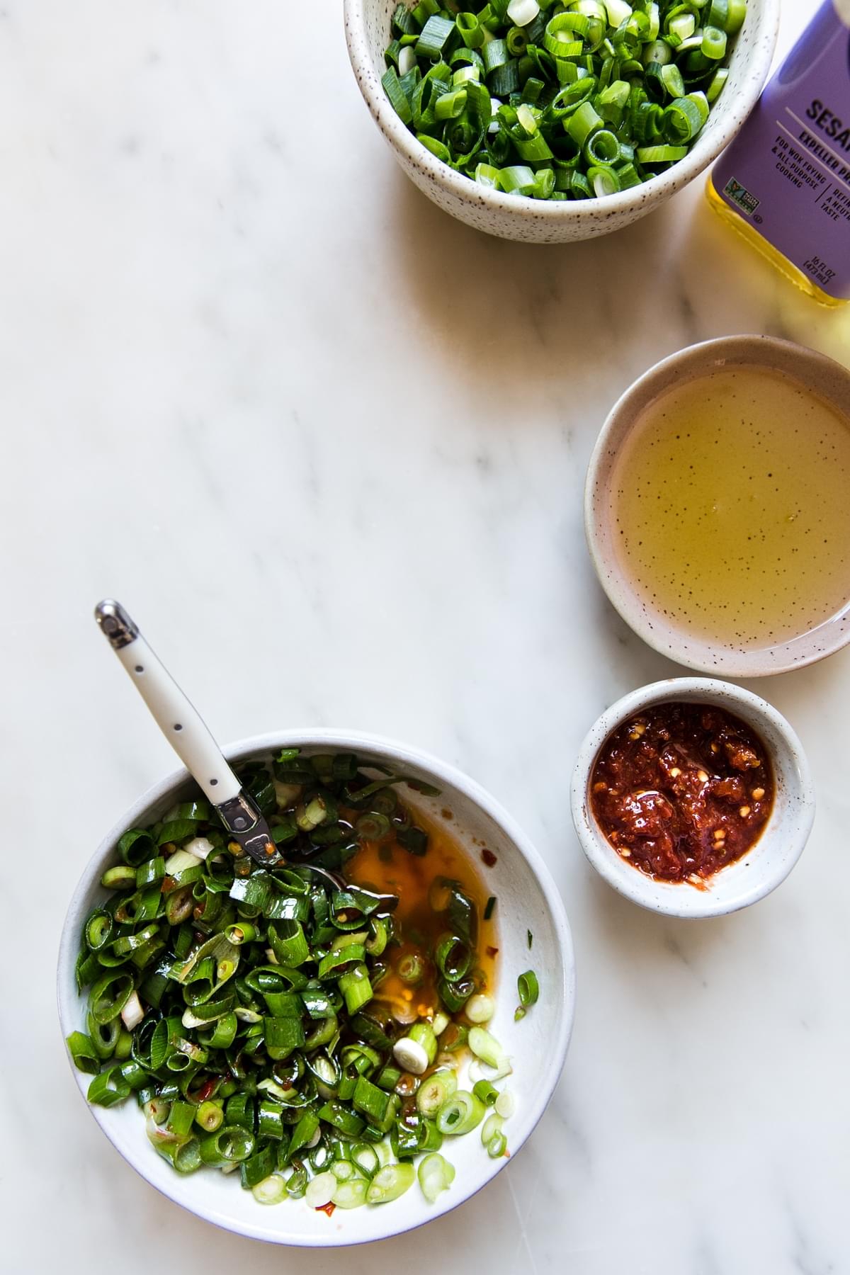 sesame oil, chili oil, scallions green onions in a bowl