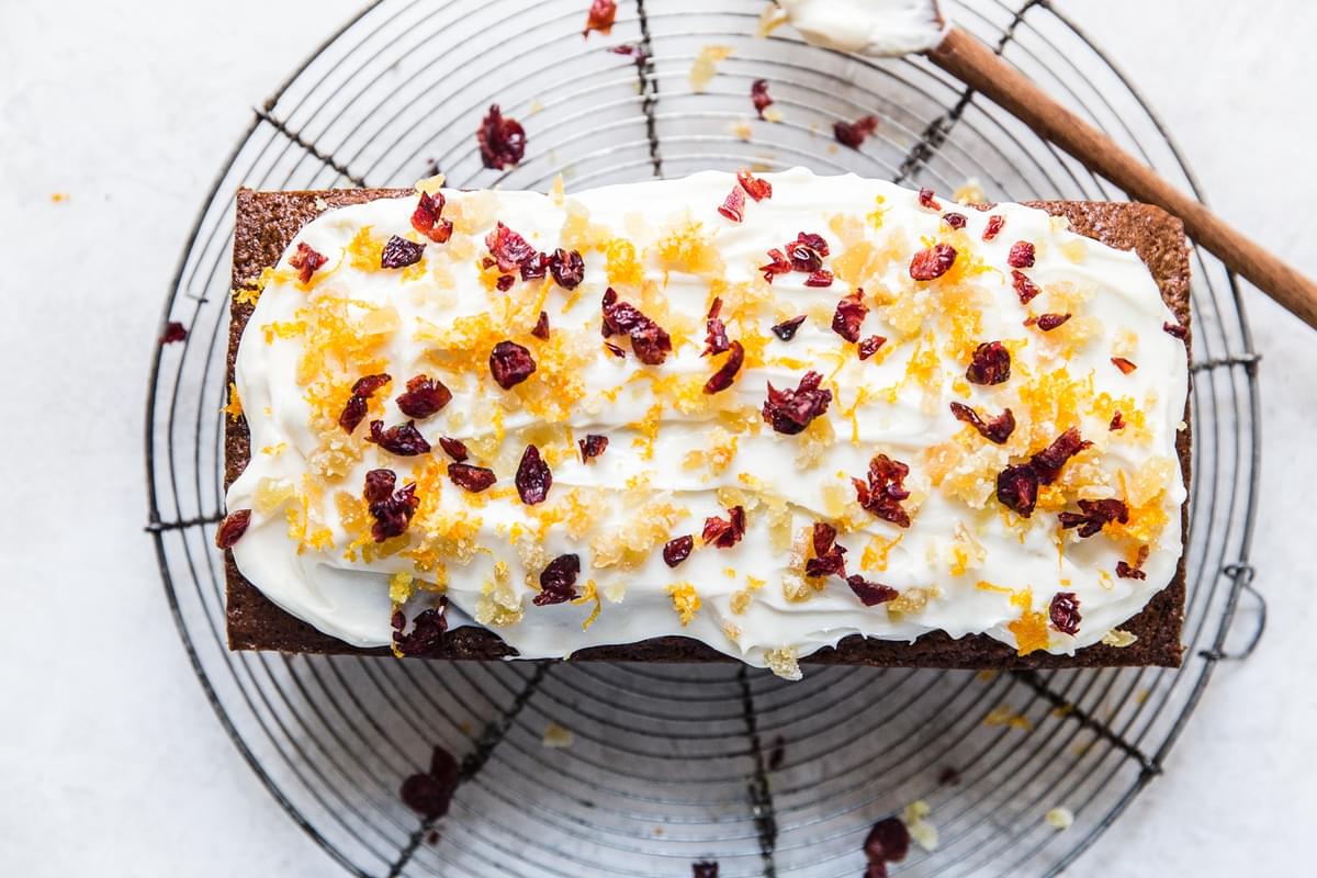 gingerbread loaf with cream cheese frosting with candied ginger, dried cranberries and orange zest.