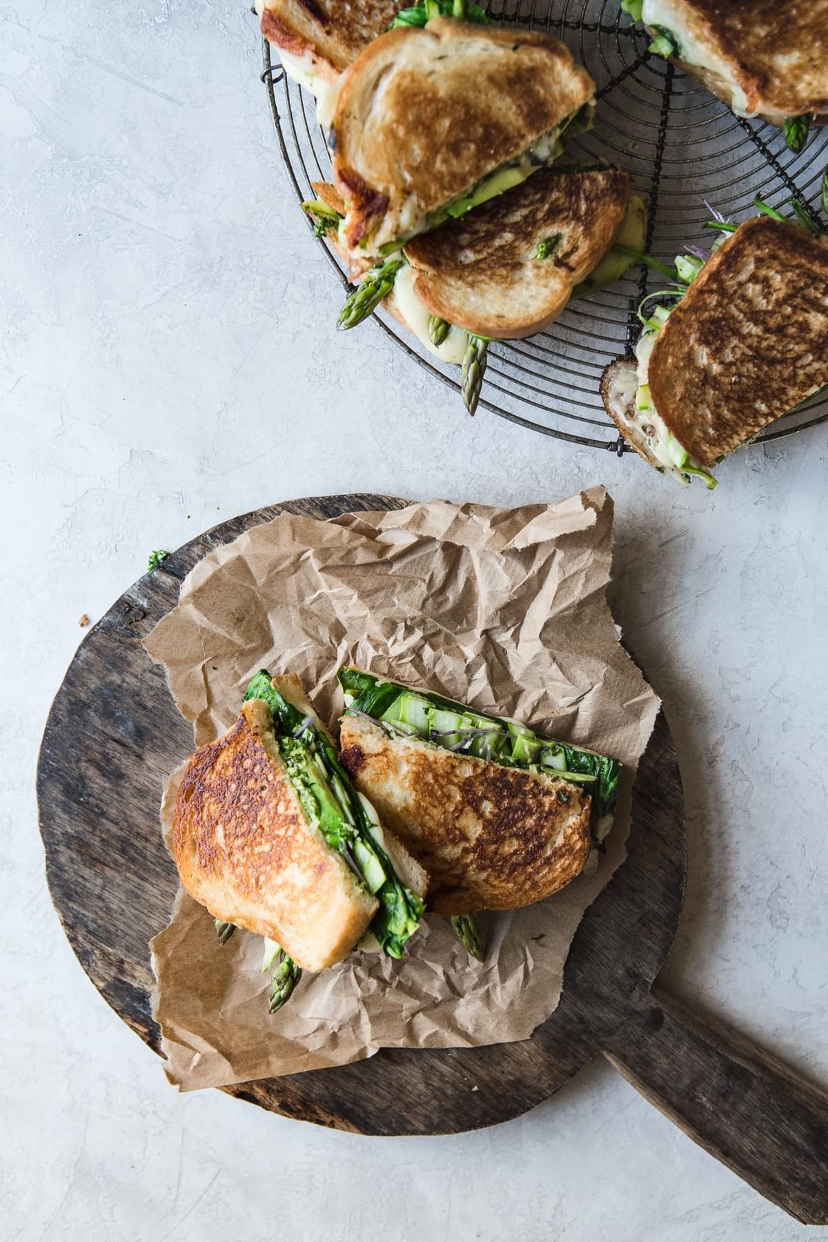 Green Goddess Grilled Cheese Sandwich sliced in half on a cutting board