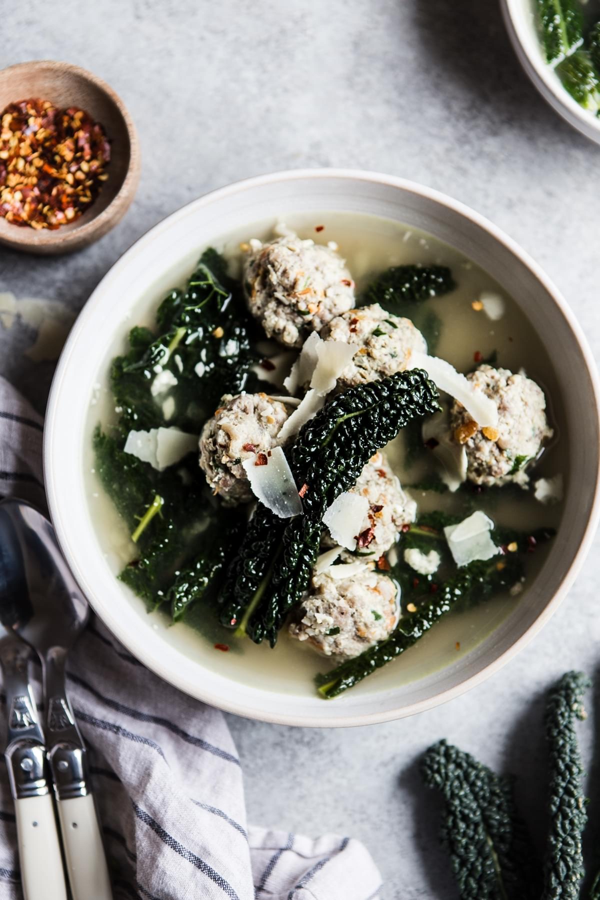 Homemade Italian wedding soup in a bowl with kale and meatballs