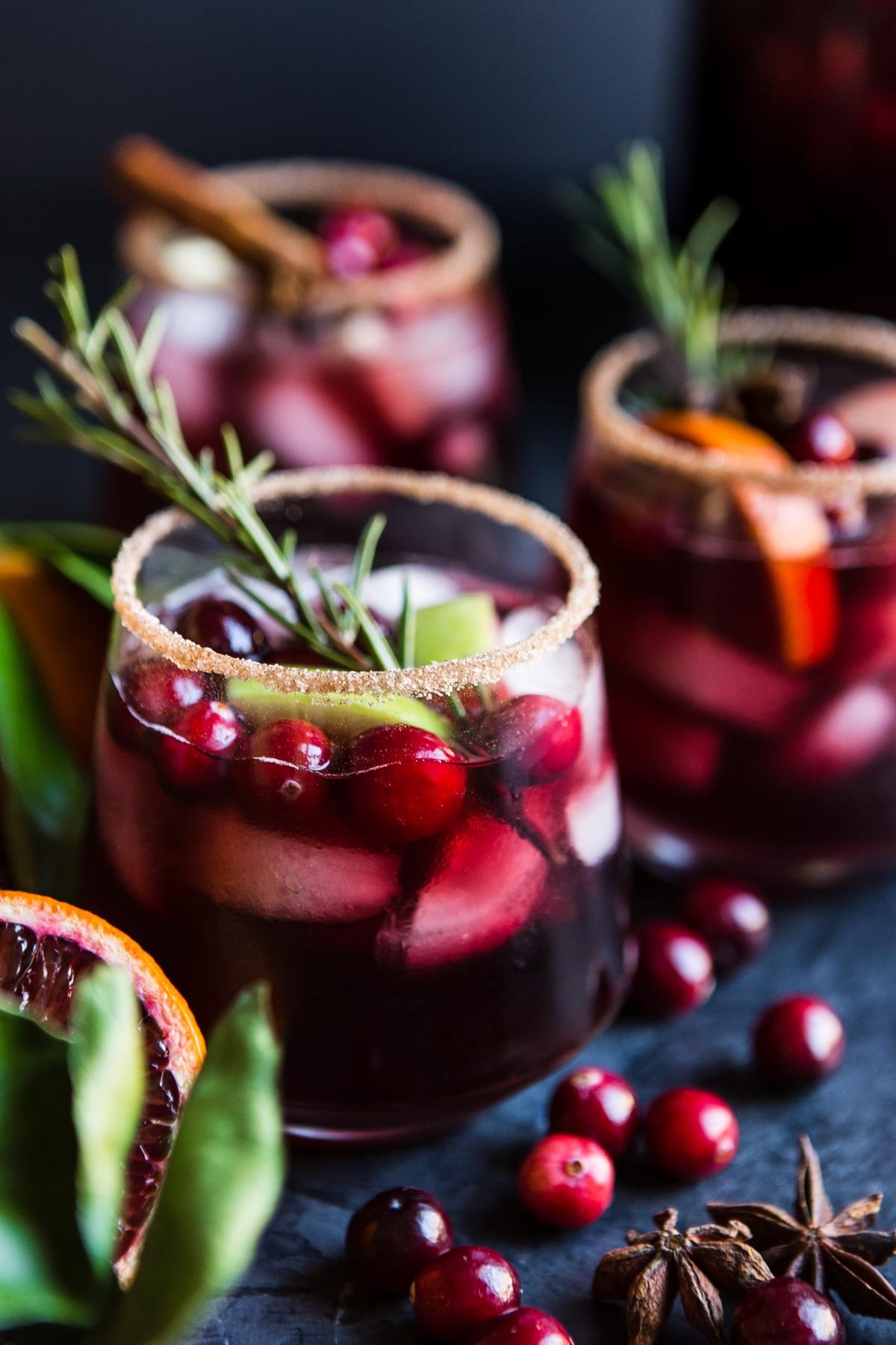 Red wine sangria with apples cranberries and oranges in a sugar rimmed glass