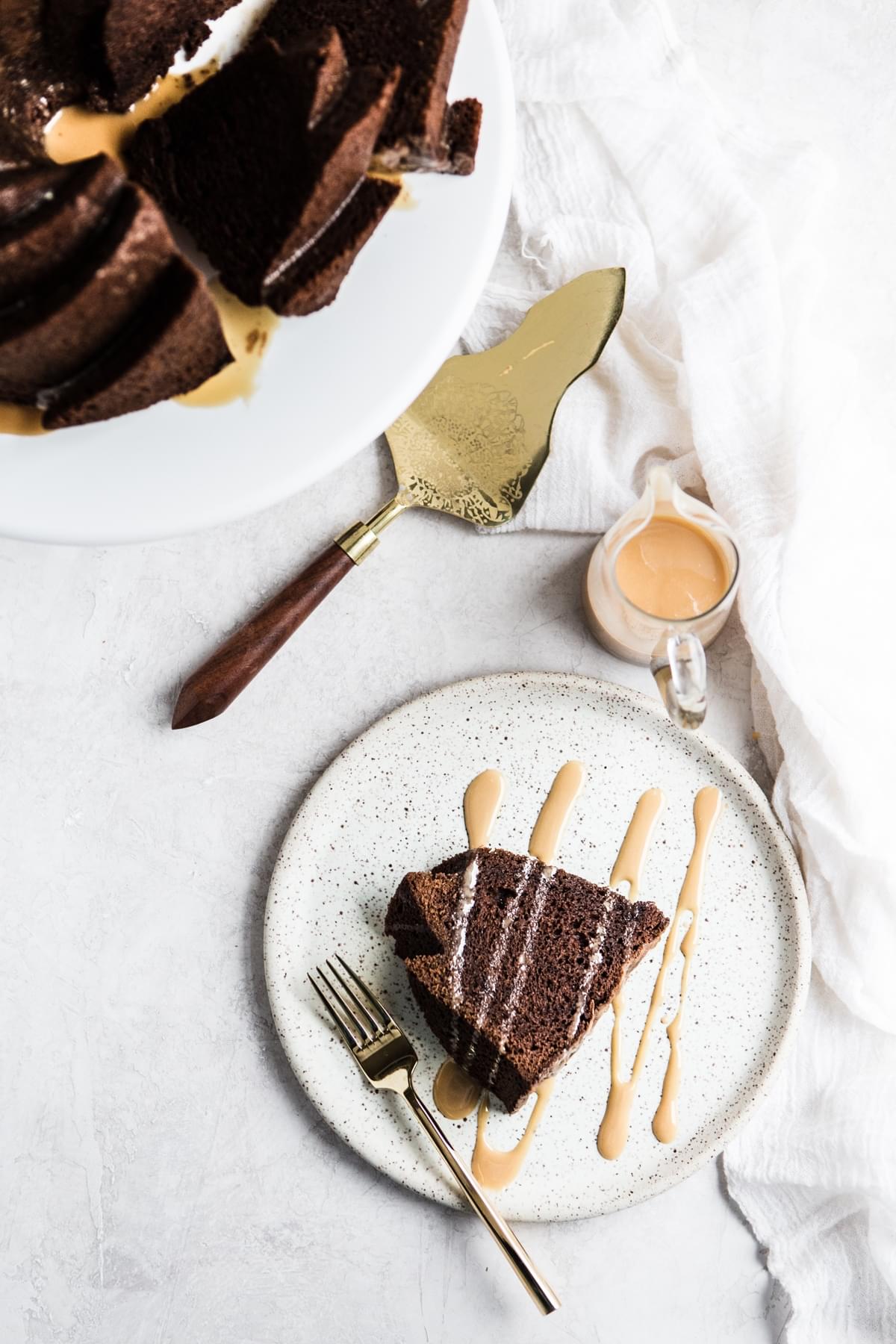 a slice of Chocolate Bundt Cake with an icing drizzle on a plate