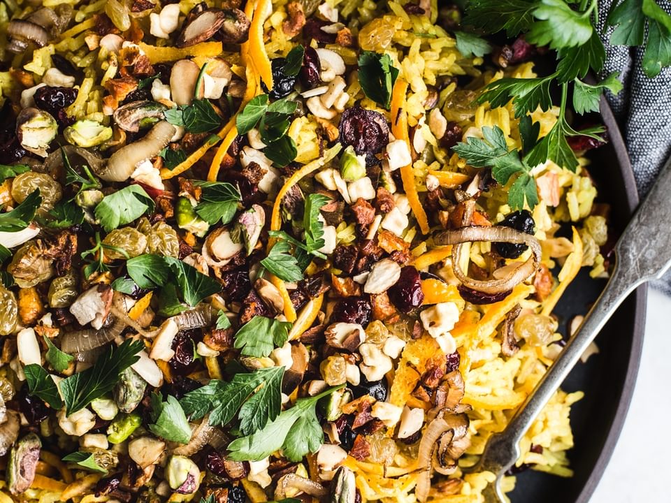 jeweled rice in a bowl yellow rice with nuts and dried fruit and herbs