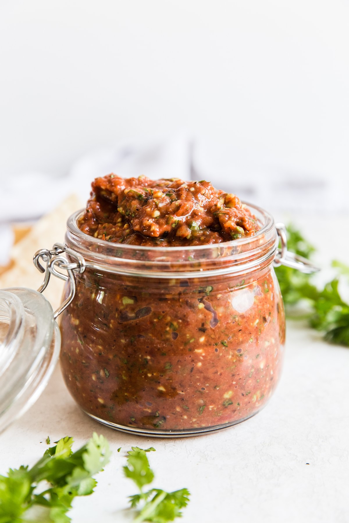 a jar of restaurant style salsa  with cilantro