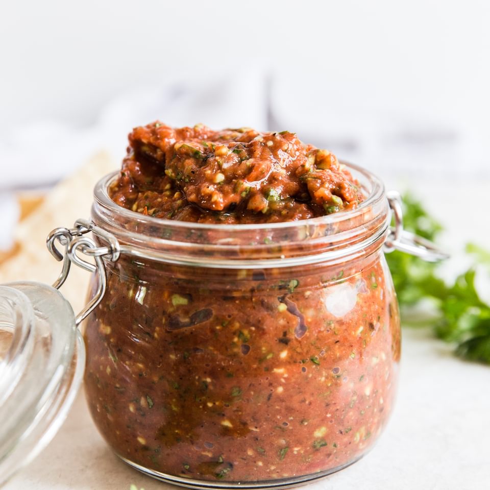 a jar of restaurant style salsa  with cilantro