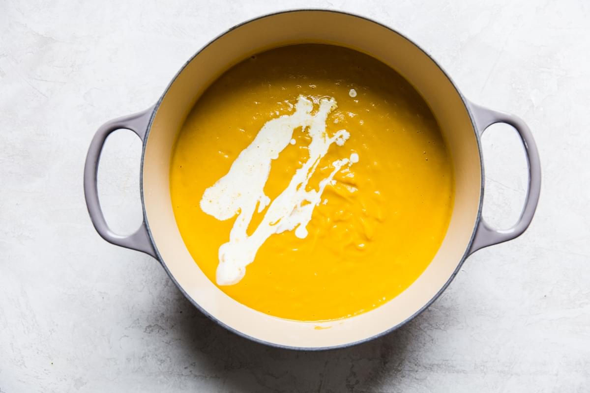 purred Roasted Butternut Squash Soup With Apples in a soup pot with cream