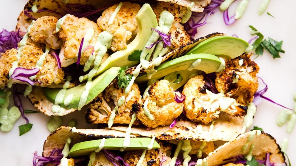 roasted cauliflower tacos with avocado cremared cabbage