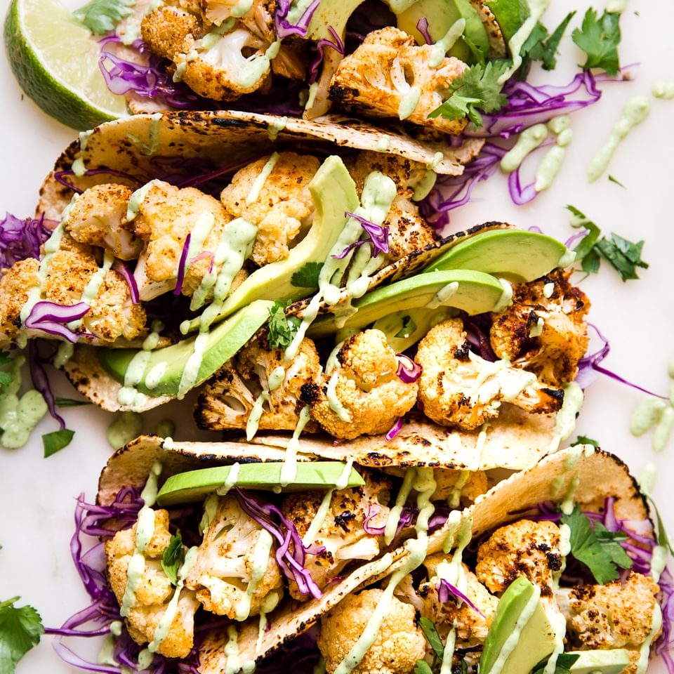 roasted cauliflower tacos with avocado cremared cabbage