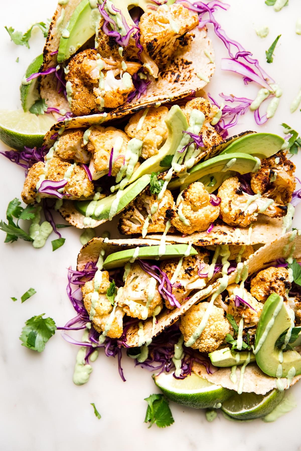 roasted cauliflower tacos with avocado crema, red cabbage