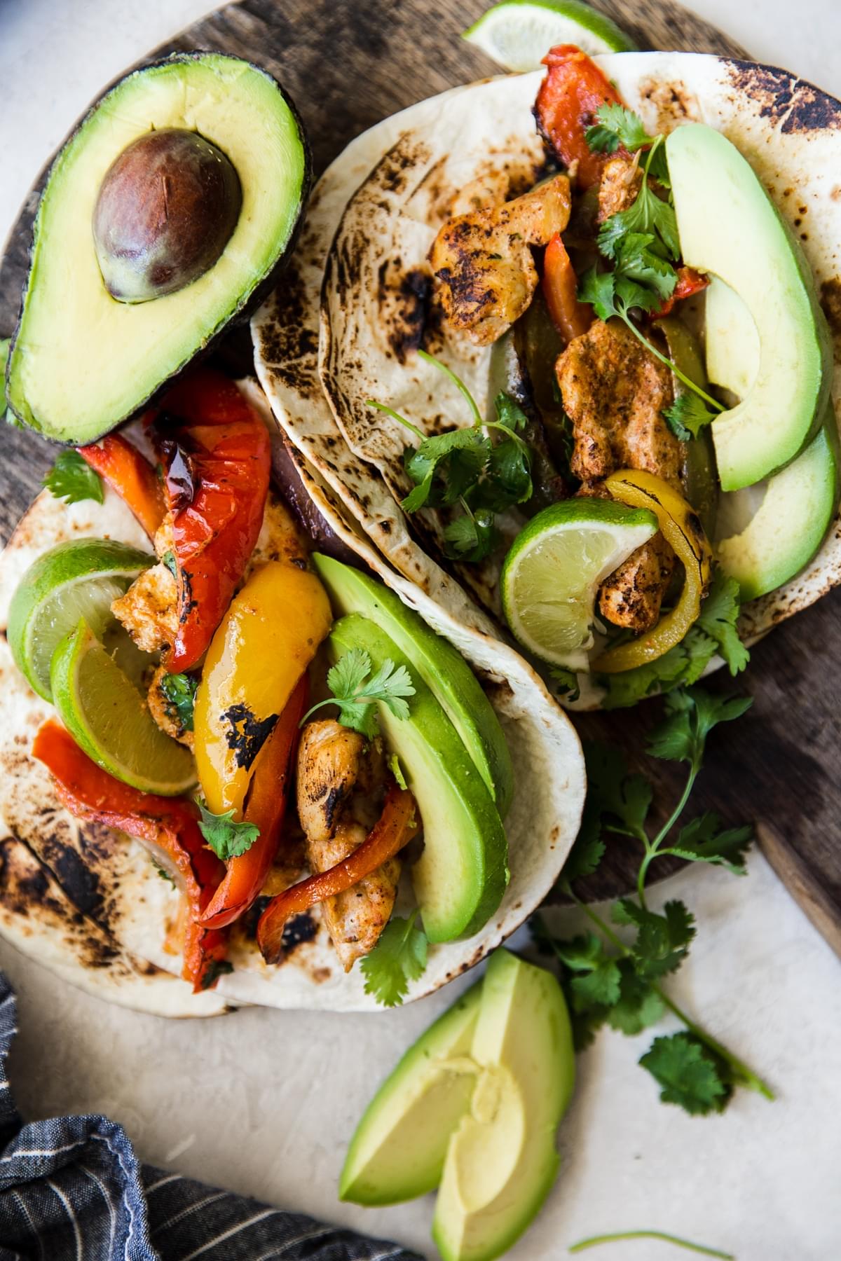 chicken fajitas on a plate with avocado and lime