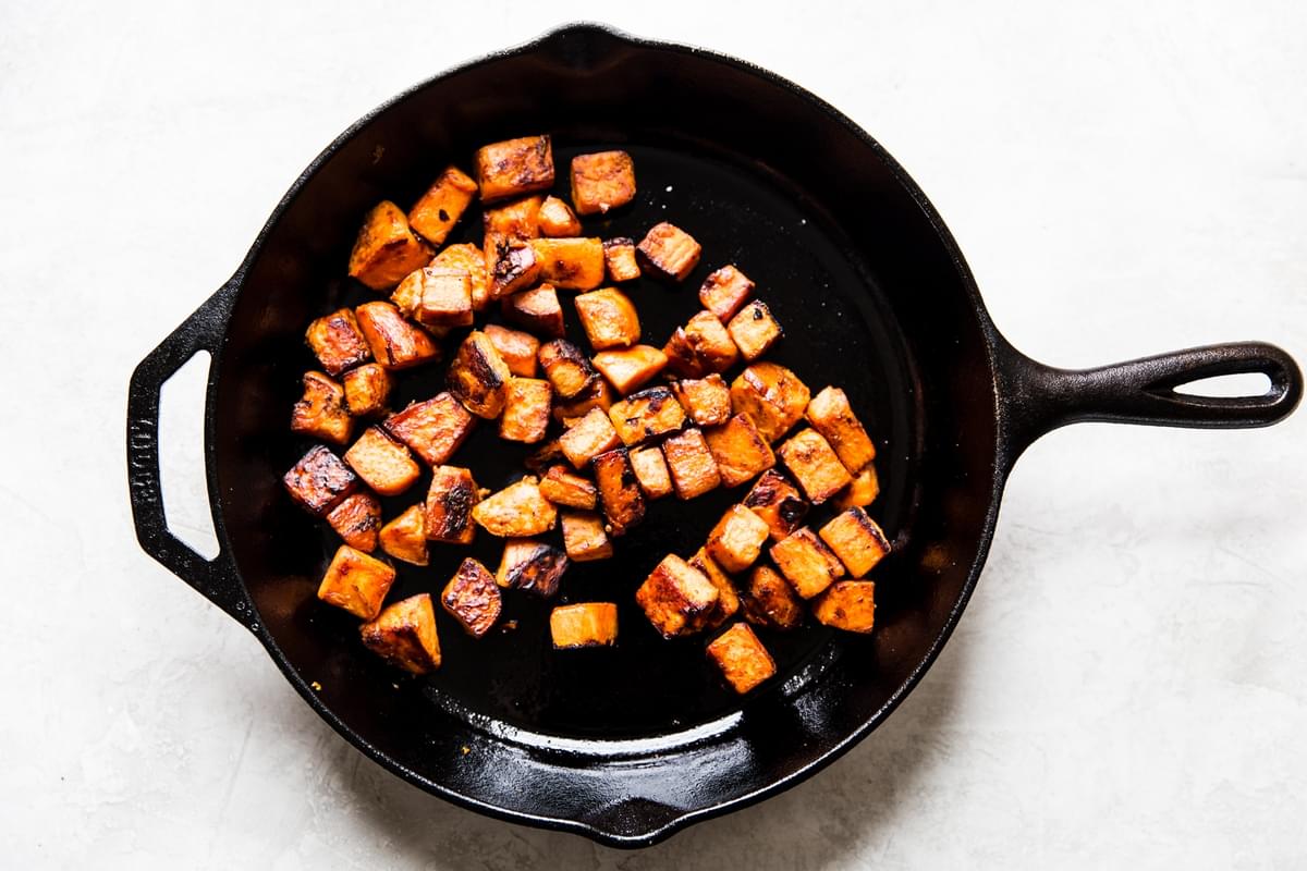 sweet potatoes sautéed in a cast iron pan