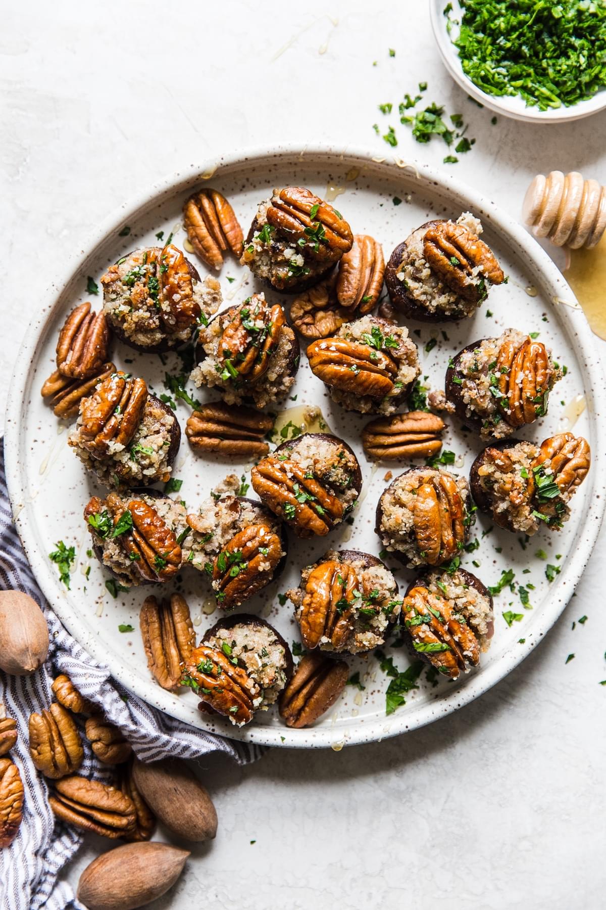 a plate with pecan and goat cheese stuffed mushrooms with  parsley and honey