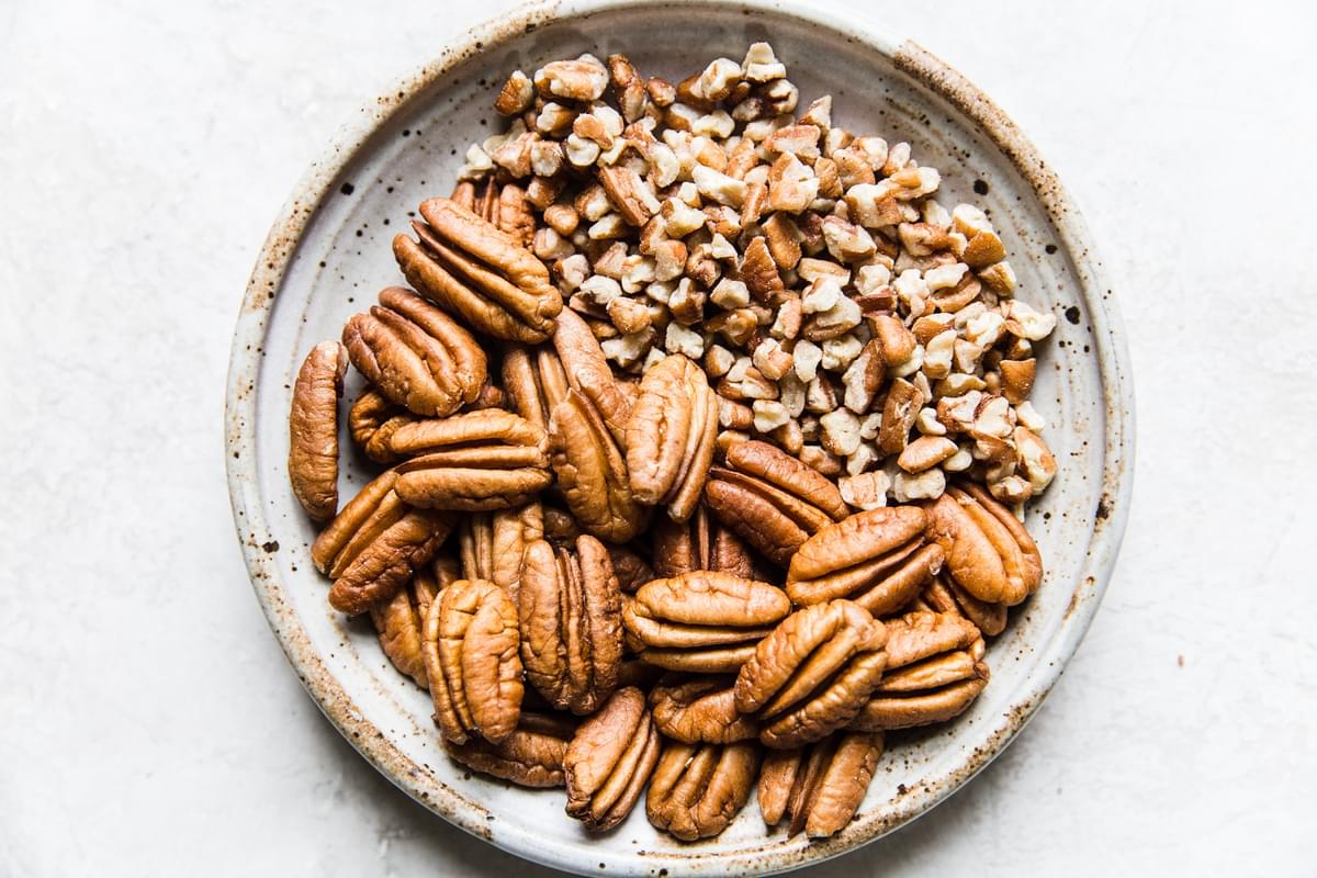 Chopped pecans and whole pecans on a plate