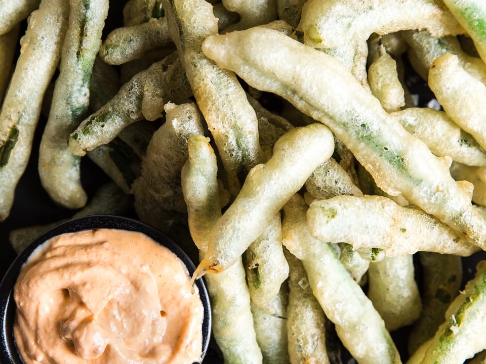 tempura green beans with curry mayonnaise on a platter