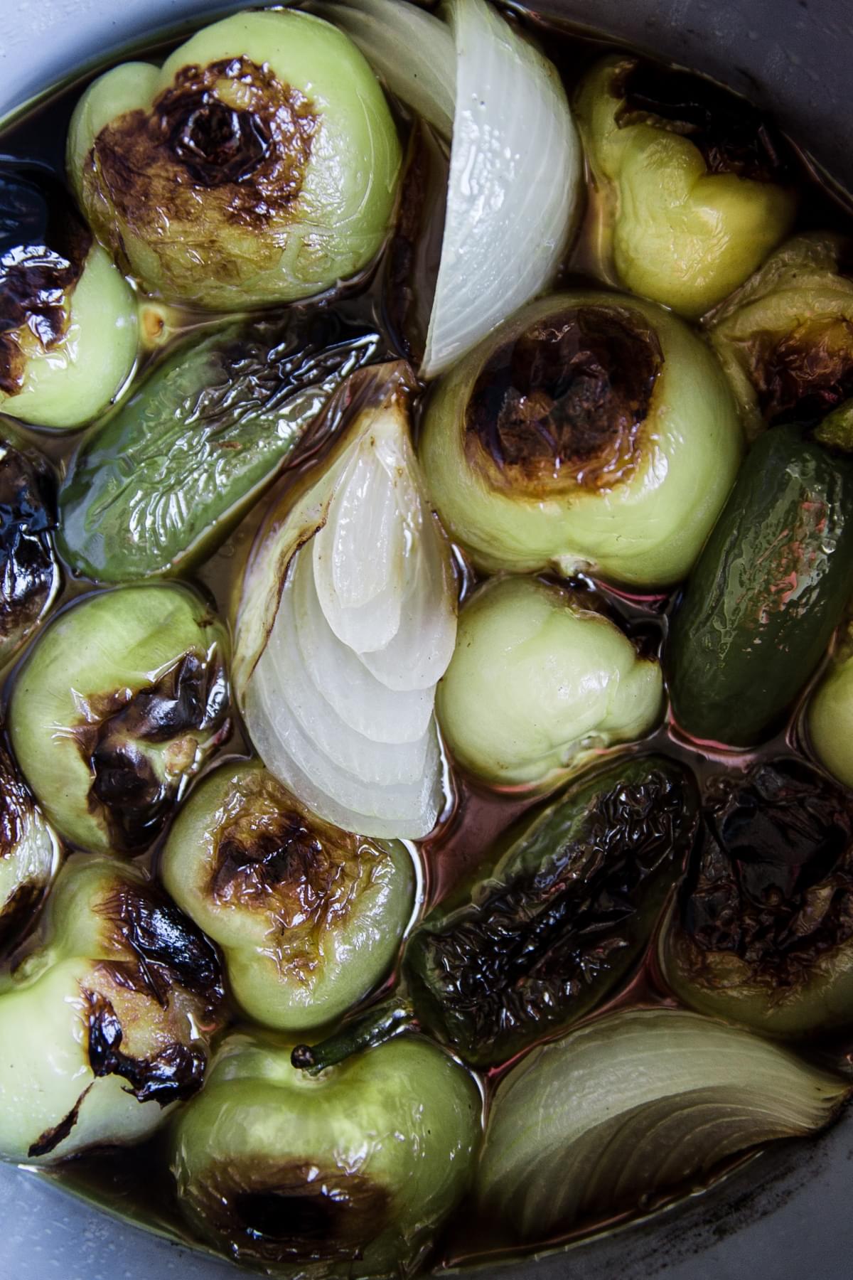 roasted tomatillos and onions and jalapeno in a pot