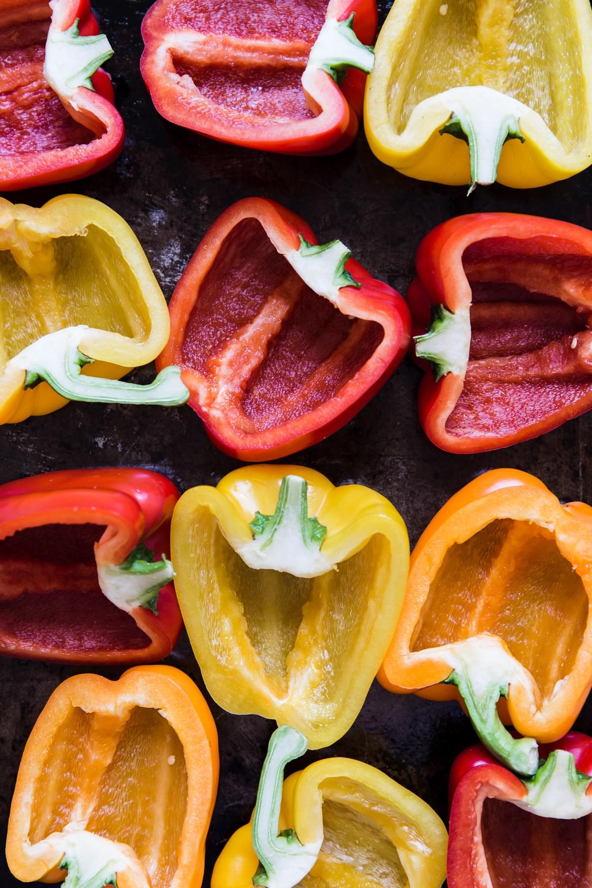 red, yellow and orange raw bell peppers cut in half