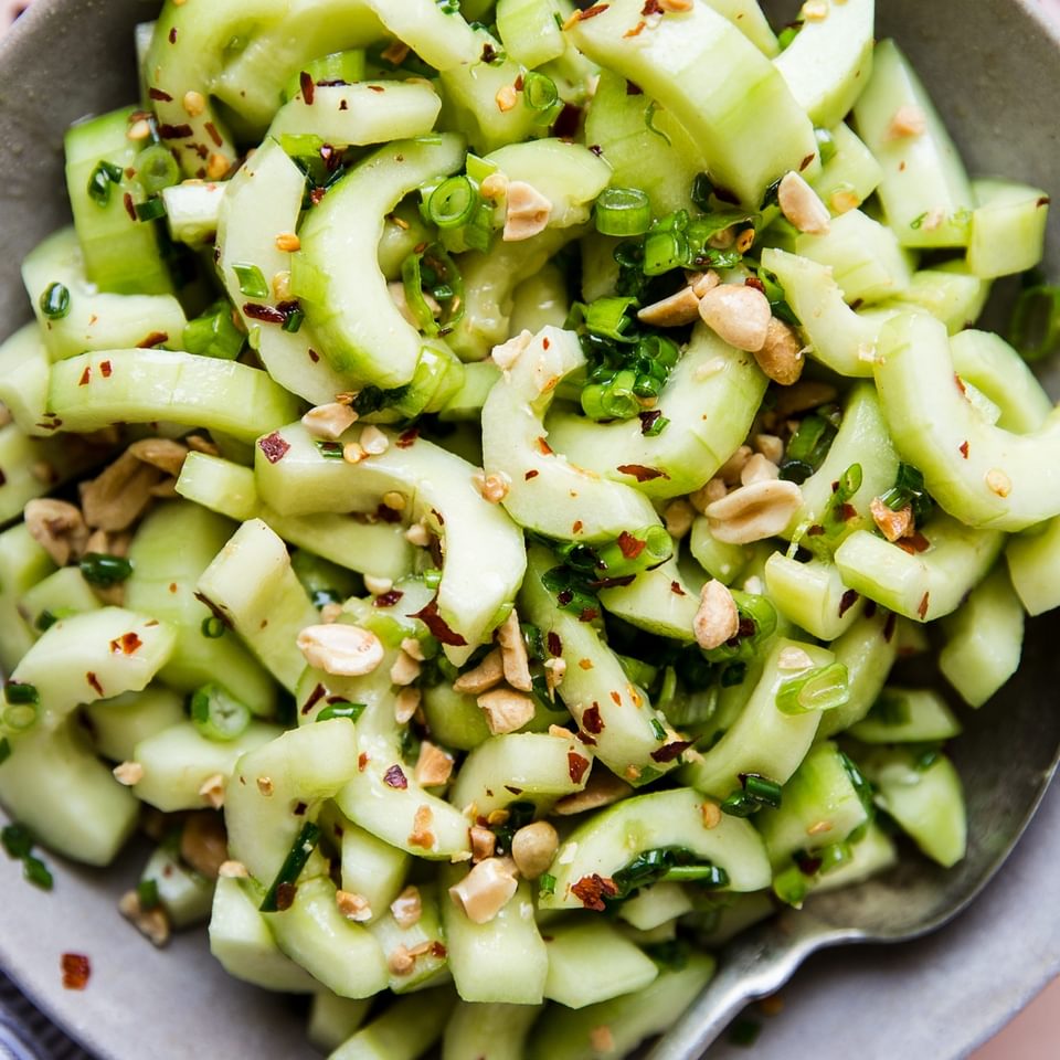 asian cucumber salad in a large bowl with a spoon