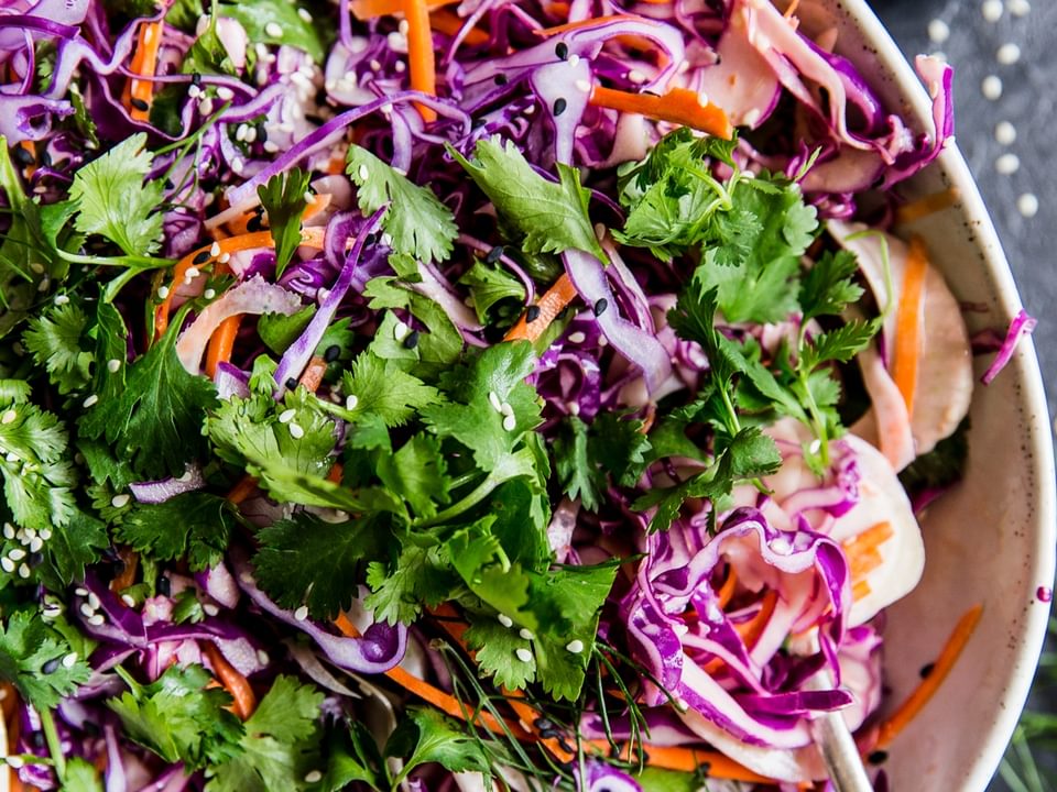 Asian Slaw With Sriracha Dressing in a bowl with a spoon