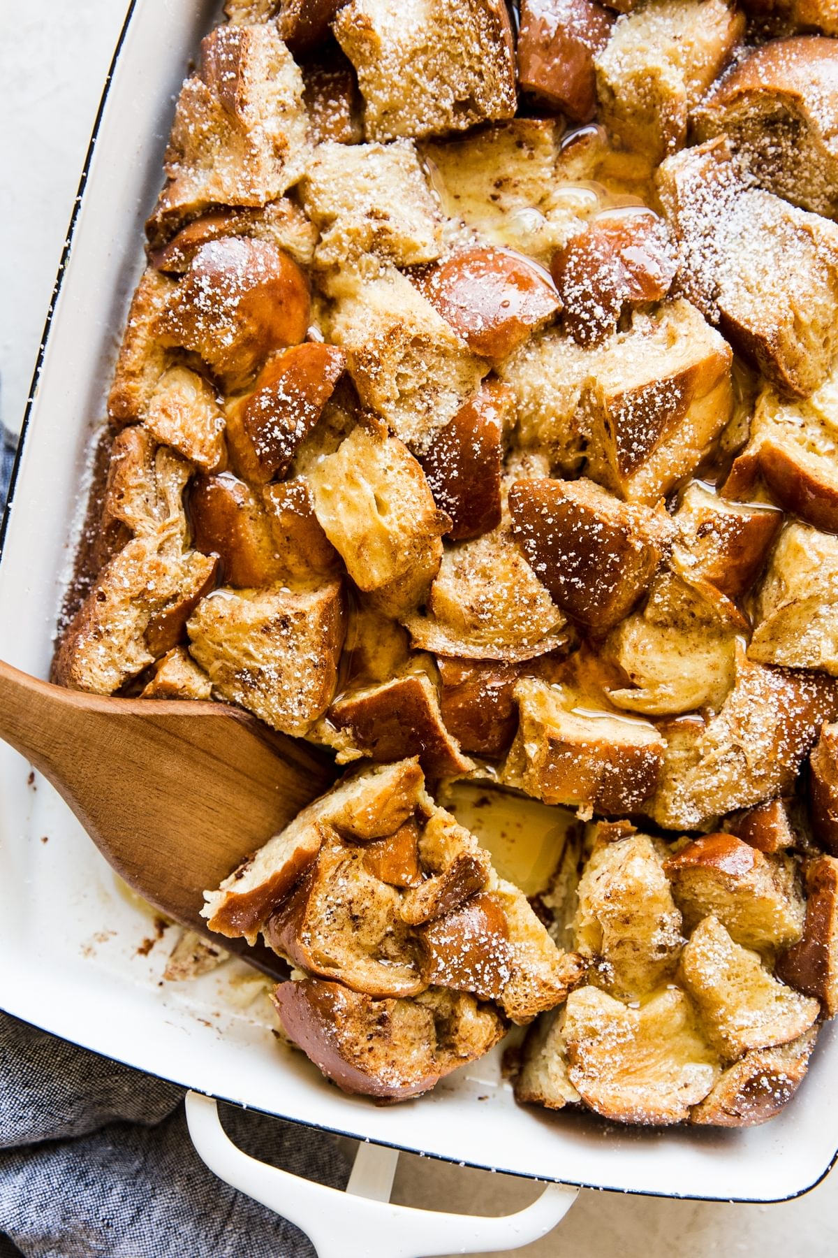 Baked French Toast recipe in a casserole dish with a wooden spoon
