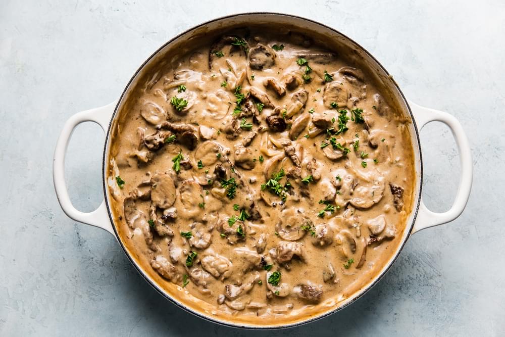 homemade beef stroganoff made with mushrooms, onions, sour cream, dijon, butter and spices sprinkled with fresh parsley