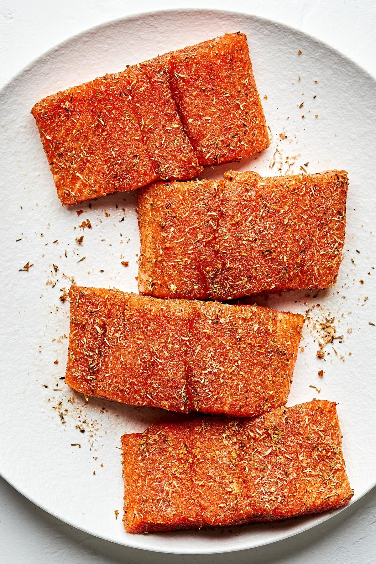 a plate of salmon rubbed with olive oil, brown sugar, paprika, garlic & onion powder, oregano, thyme, ginger, salt & cayenne