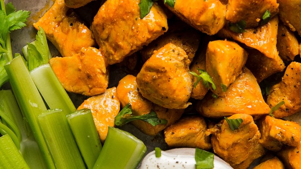Buffalo Chicken Bites with Blue Cheese Dressing and celery on a plate