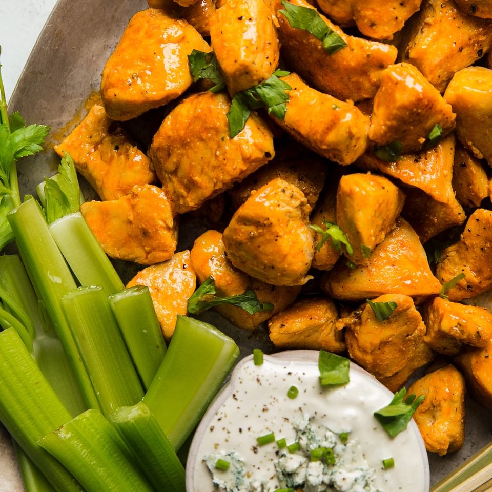 Buffalo Chicken Bites with Blue Cheese Dressing and celery on a plate
