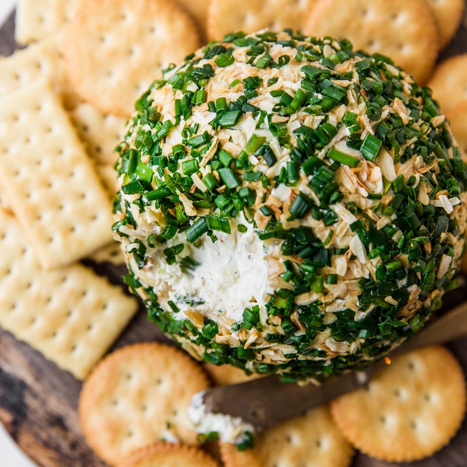 Cheddar And Onion Cheeseball on a platter with crackers