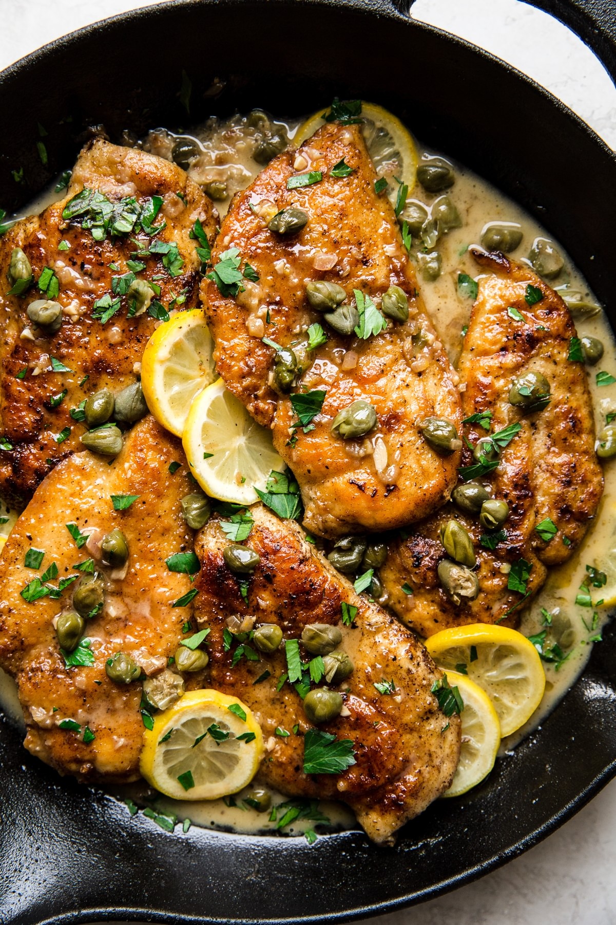 Chicken Picatta with lemon and capers in a cast iron skillet