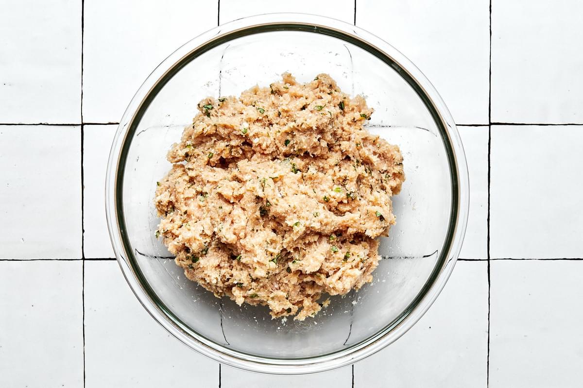 ground chicken, salt, egg, fennel seeds, Parmesan, garlic, basil, and bread crumbs mixed together in a glass bowl