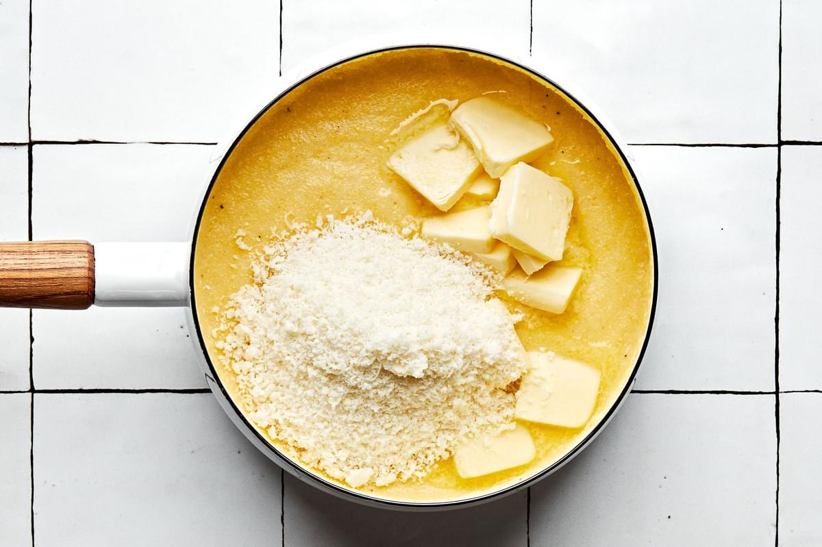 polenta, milk, chicken stock, butter and parmesan being cooked in a pot